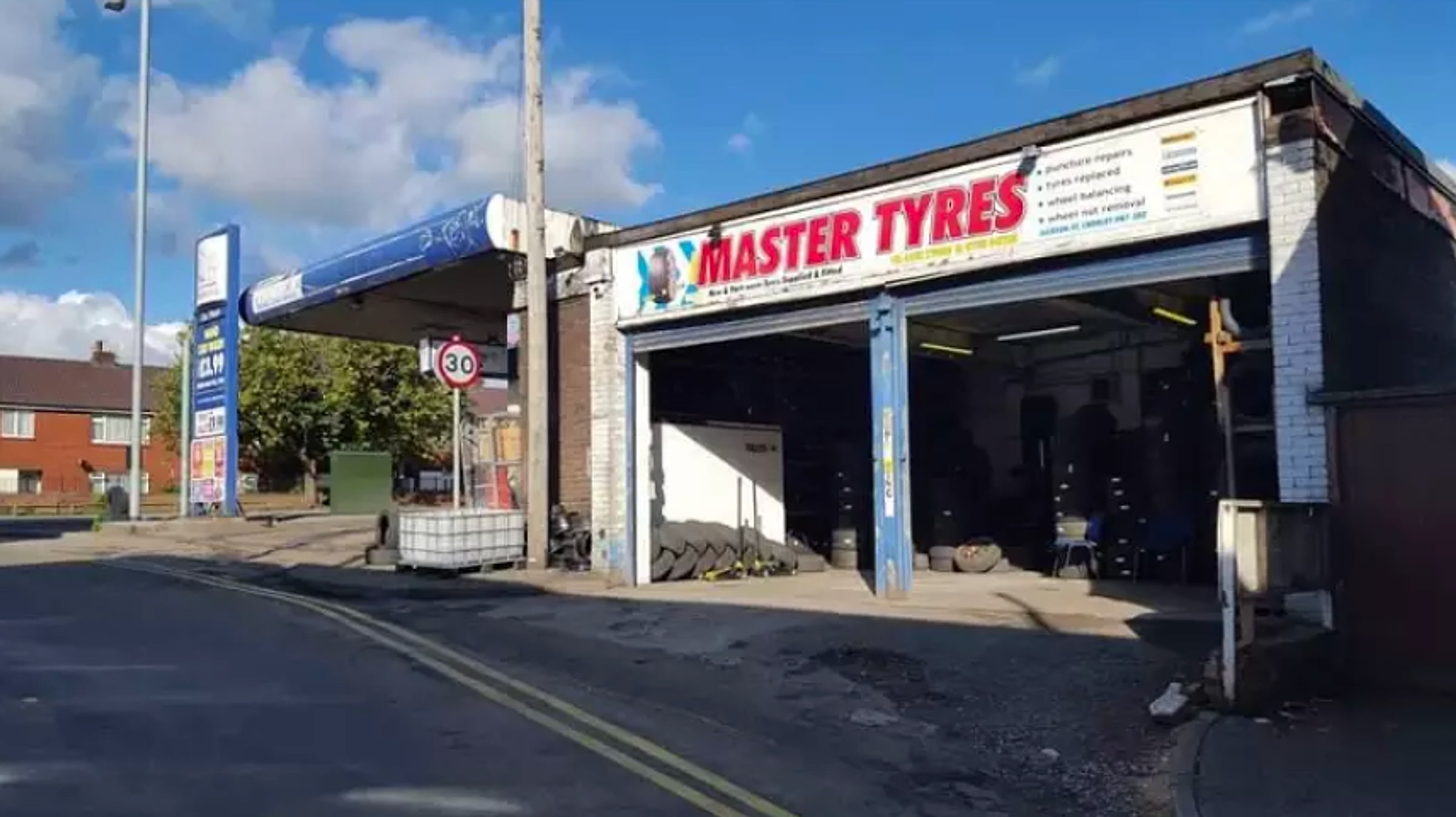 The Master Tyres shop front on Jackson Street, off Bolton Street, Chorley, with tyres stacked inside the open workshop